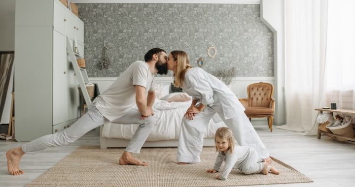 A family enjoying playful bonding moments in a stylish, minimalistic bedroom setting.